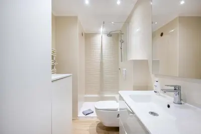a white bathroom with a toilet and a sink at Agence des Résidences - Appartements privés du 45 CROISETTE - Standard in Cannes