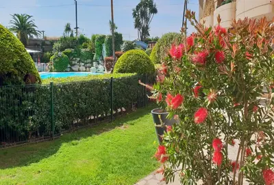 a garden with red flowers and a fence at Sea view La Palme d'Azur apartment steps away from the beach and perfect for holidays & business trips in Cannes