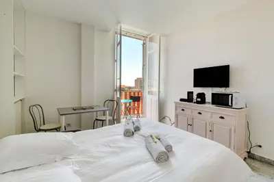 a bedroom with a white bed with towels on it at IMMOGROOM - Studio - Sea view next to the Palais - CONGRESSBEACHES in Cannes