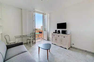 a living room with a couch and a tv and a table at IMMOGROOM - Studio - Sea view next to the Palais - CONGRESSBEACHES in Cannes