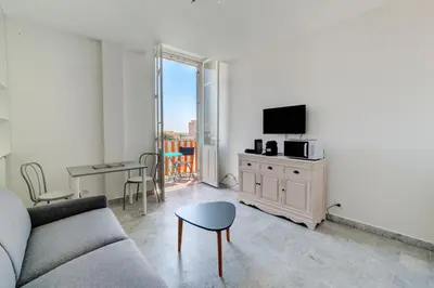 a living room with a couch and a tv and a table at IMMOGROOM - Studio - Sea view next to the Palais - CONGRESSBEACHES in Cannes