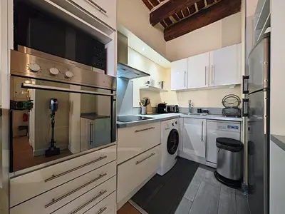a kitchen with white cabinets and a washer and dryer at Croisette carre d'or in Cannes