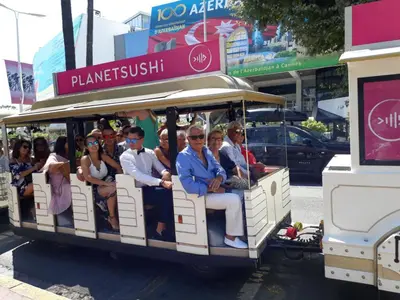 a group of people riding on a trolley at Croisette carre d'or in Cannes