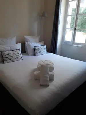 a white bed with towels on it with a window at Croisette carre d'or in Cannes