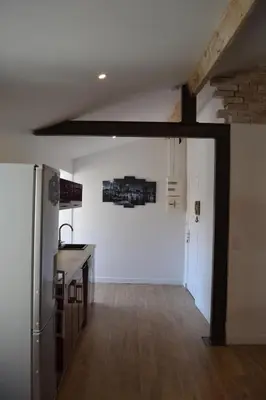a kitchen with a white wall and a refrigerator at 2 pièces Vagliano in Cannes