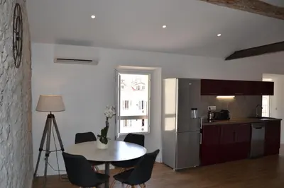 a kitchen and a table in a room with a table and chairs at 2 pièces Vagliano in Cannes