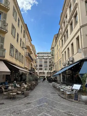 a city street with tables and chairs and buildings at 2 pièces Vagliano in Cannes