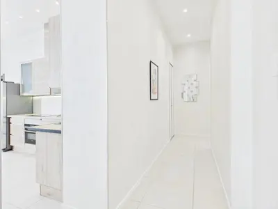 a white kitchen with white walls and white tile floors at Residence du Louvre - Apartments - Prime location Palais & Croisette - Luxury Stay by LRA Cannes in Cannes