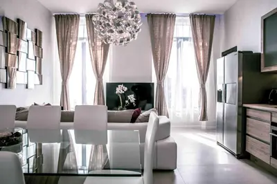 a living room with a chandelier and a table and chairs at Residence du Louvre - Apartments - Prime location Palais & Croisette - Luxury Stay by LRA Cannes in Cannes