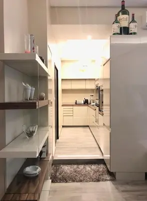 a kitchen with white cabinets and a rug at NUMA BLANC 300 M PALAIS DES FESTIVALS in Cannes