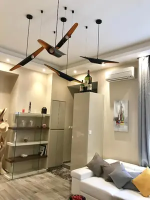a living room with a ceiling fan and a couch at NUMA BLANC 300 M PALAIS DES FESTIVALS in Cannes