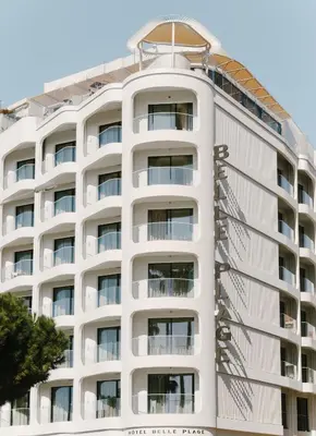 a white apartment building with a white facade at Hôtel & Spa Belle Plage in Cannes