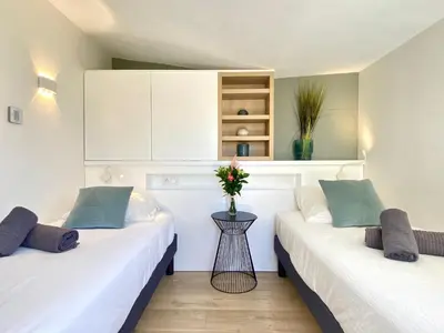two beds in a room with white walls at Luxury 