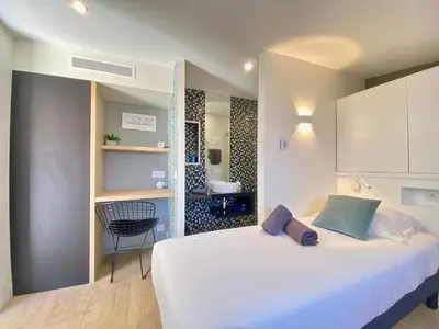 a bedroom with a large white bed and a bathroom at Luxury 