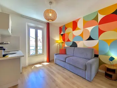 a living room with a couch and a colorful wall at Studio Luxury Toîts du Soleil By SCLS Locations in Cannes