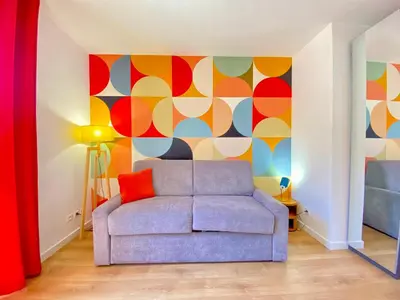 a living room with a couch and a colorful wall at Studio Luxury Toîts du Soleil By SCLS Locations in Cannes