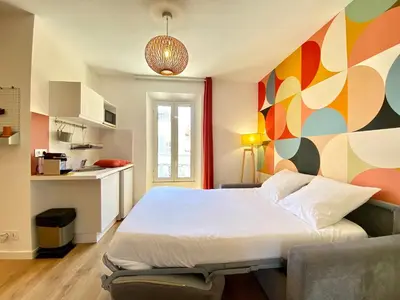 a bedroom with a large bed with a colorful wall at Studio Luxury Toîts du Soleil By SCLS Locations in Cannes