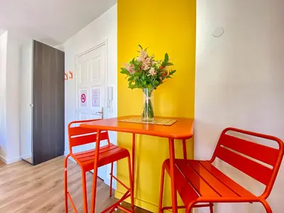a table with a vase of flowers and two chairs at Studio Luxury Toîts du Soleil By SCLS Locations in Cannes