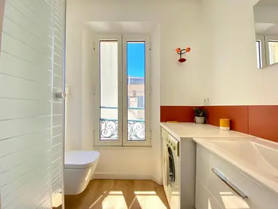 a bathroom with a toilet and a sink and a window at Studio Luxury Toîts du Soleil By SCLS Locations in Cannes