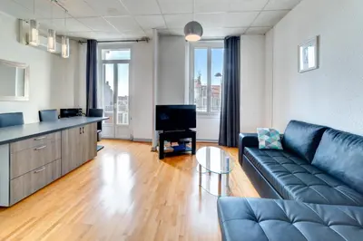 a living room with a couch and a television at IMMOGROOM - Charming apartment - City Center - Wifi - AC in Cannes