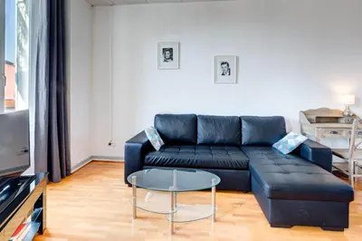 a living room with a black couch and a table at IMMOGROOM - Charming apartment - City Center - Wifi - AC in Cannes
