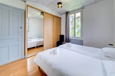 a bedroom with two beds and a mirror at IMMOGROOM - Charming apartment - City Center - Wifi - AC in Cannes