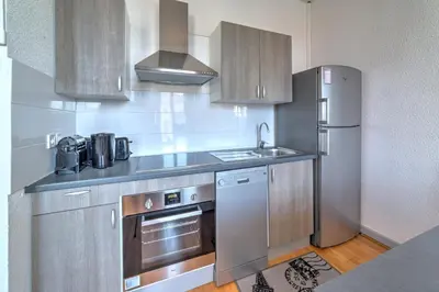a kitchen with a stainless steel refrigerator and a sink at IMMOGROOM - Charming apartment - City Center - Wifi - AC in Cannes
