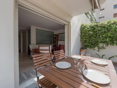 a wooden table and chairs on a patio at Apartment Villa Schneider by Interhome in Cannes