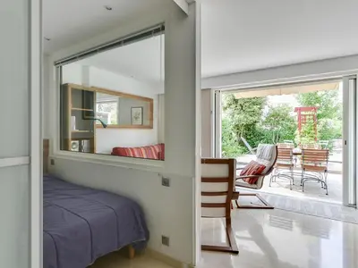 a bedroom with a mirror and a bed and a patio at Apartment Villa Schneider by Interhome in Cannes
