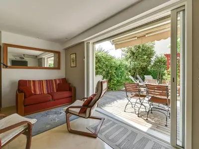 a living room with a red couch and a patio at Apartment Villa Schneider by Interhome in Cannes