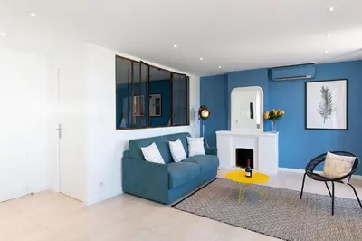 a living room with blue walls and a blue couch at Maracuja YourHostHelper in Cannes