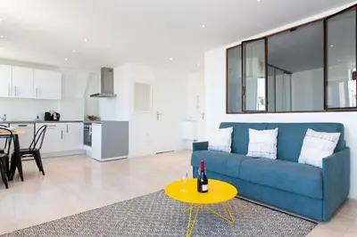 a living room with a blue couch and a yellow table at Maracuja YourHostHelper in Cannes