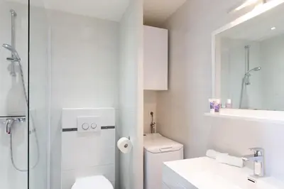 a white bathroom with a toilet and a shower at Maracuja YourHostHelper in Cannes