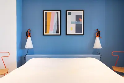 a blue bedroom with a bed and two framed pictures at Maracuja YourHostHelper in Cannes