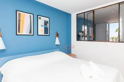 a blue bedroom with a white bed and windows at Maracuja YourHostHelper in Cannes