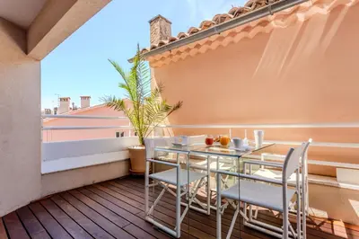 a balcony with a table and chairs on a roof at Hôtel Traverse Des Artistes in Cannes
