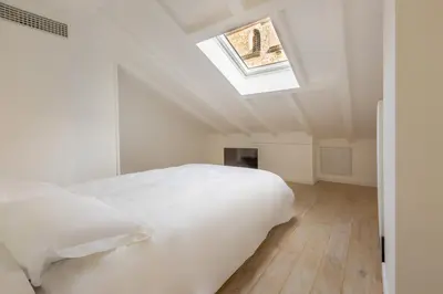 a bedroom with a white bed and a skylight at Hôtel Traverse Des Artistes in Cannes