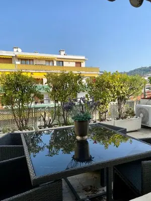 a table with a potted plant on top of a balcony at Arthur Properties Rue d'Antibes in Cannes