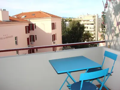 a blue table and chairs on a balcony at ACCI Cannes Les Yuccas in Cannes