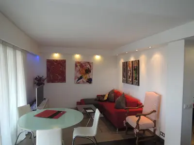 a living room with a red couch and a table at ACCI Cannes Les Yuccas in Cannes