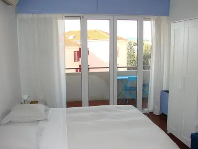 a bedroom with a white bed and a large window at ACCI Cannes Les Yuccas in Cannes