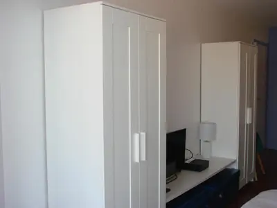 a white cabinet with a television in a bedroom at ACCI Cannes Les Yuccas in Cannes