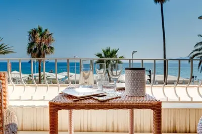a table on a balcony with a view of the beach at IMMOGROOM - 3 Sea view Panoramic terrace - 1 min beach - CONGRESSBEACH in Cannes