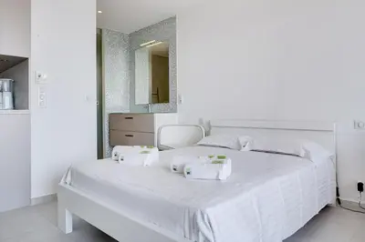 a white bedroom with a white bed with towels on it at IMMOGROOM - 3 Sea view Panoramic terrace - 1 min beach - CONGRESSBEACH in Cannes