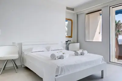 a white bedroom with a white bed with towels on it at IMMOGROOM - 3 Sea view Panoramic terrace - 1 min beach - CONGRESSBEACH in Cannes