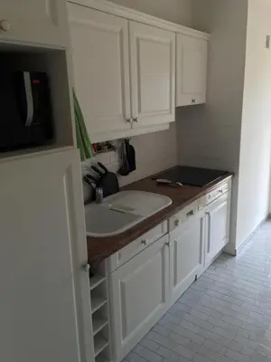 a kitchen with white cabinets and a sink at Cannes: Agréable 2 pièces vue mer panoramique in Cannes
