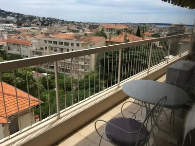 a balcony with a table and a view of a city at Cannes: Agréable 2 pièces vue mer panoramique in Cannes