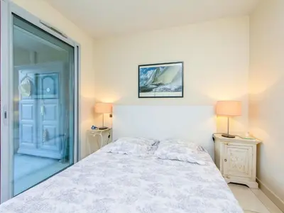 a bedroom with a bed and two lamps and a door at Apartment Cristal Croisette-1 by Interhome in Cannes