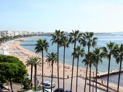 a view of a beach with palm trees and the ocean at Apartment Cristal Croisette-1 by Interhome in Cannes