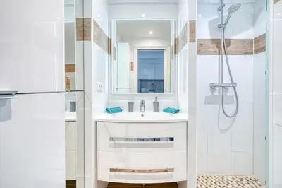 a white bathroom with a sink and a shower at Le Marignan in Cannes